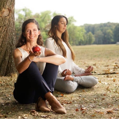gesunde-fuehrung_fuehrungscoaching_resilienz Gesunde Führung, Moderne Führung, lächelnde Frau hält Apfel