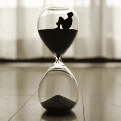 Persönlichkeitsentwicklung Coaching, Zeit-und Selbstmanagement, Figur sitzt in Sanduhr