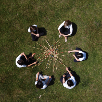 teamfuehrung_teammeetings-gestalten_frauen-mit-mikado-im-kreis Teamführung, Teammeeting gestalten, Frauen sitzen im Kreis vor Mikadostäben