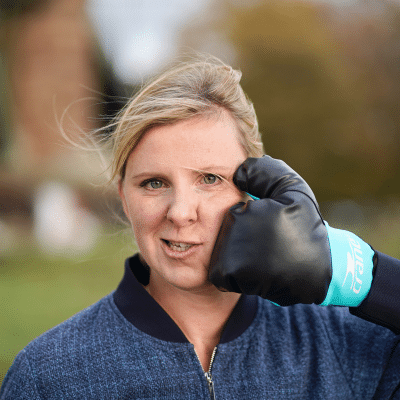 Gesund Arbeiten, Anti-Ärger-Training, Frau mit Boxhandschuh an der Wange