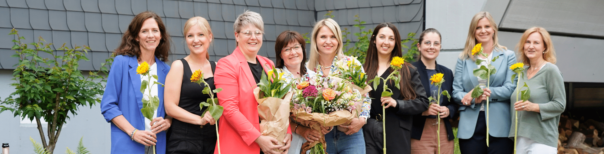 Agentur für Freundlichkeit, neun Frauen des Teams mit Sonnenblumen, Köln