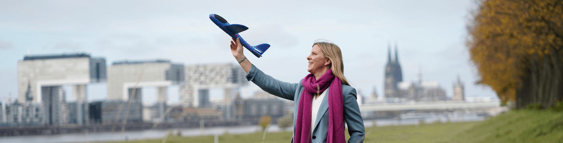 Mareen Ilgner, Beraterin und Coach der Agentur für Freundlichkeit Köln, Frau mit Flugzeug vor Kölner Dom