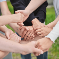 Team-Kommunikation verbessern, Teamzusammenhalt stärken, Netz aus Händen, die ineinander greifen und halten